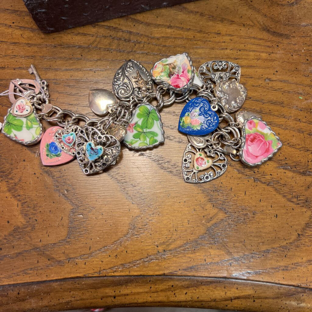 Sterling silver charm bracelet with various metal and porcelain hearts